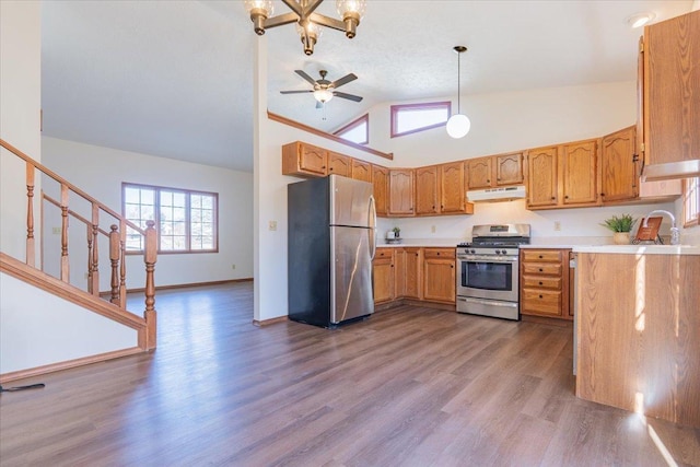 kitchen with baseboards, dark wood-style floors, stainless steel appliances, light countertops, and under cabinet range hood