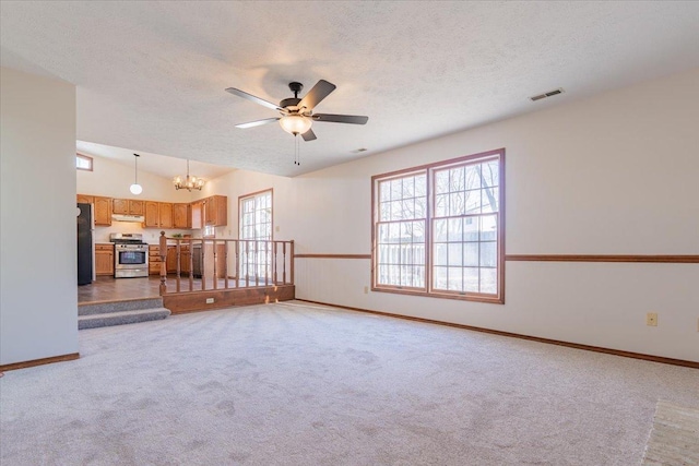 unfurnished living room featuring visible vents, vaulted ceiling, a textured ceiling, and carpet flooring