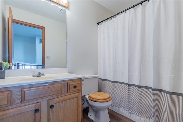 full bathroom featuring a shower with curtain, vanity, toilet, and wood finished floors