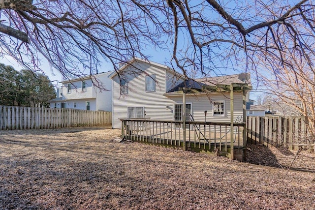 rear view of property featuring a deck and a fenced backyard