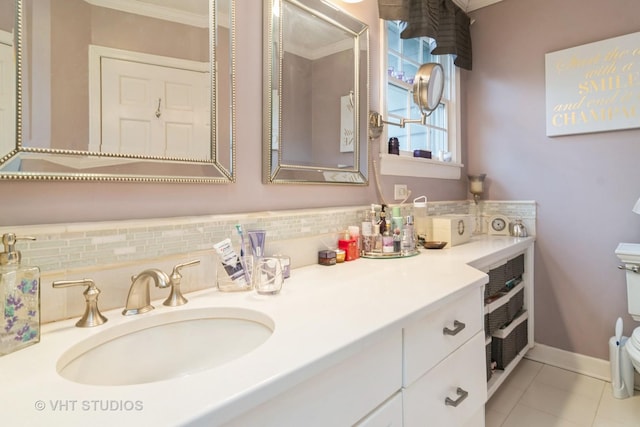 bathroom with tile patterned floors, vanity, baseboards, backsplash, and toilet