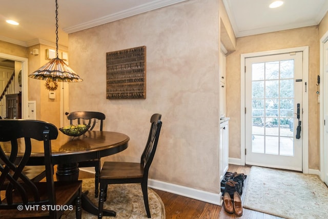 dining room featuring recessed lighting, crown molding, baseboards, and wood finished floors