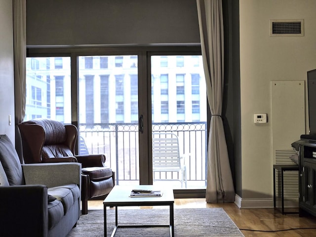 living area featuring visible vents, baseboards, and wood finished floors