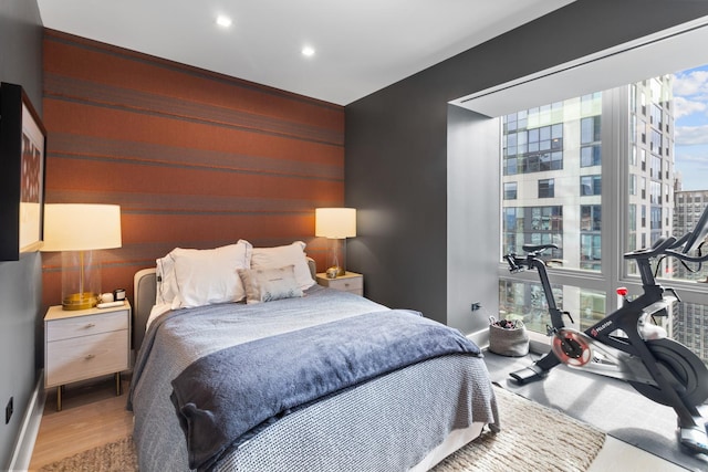 bedroom with multiple windows, baseboards, wood finished floors, and recessed lighting