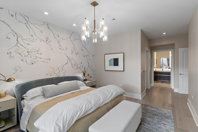 bedroom with an accent wall, baseboards, wood finished floors, and recessed lighting