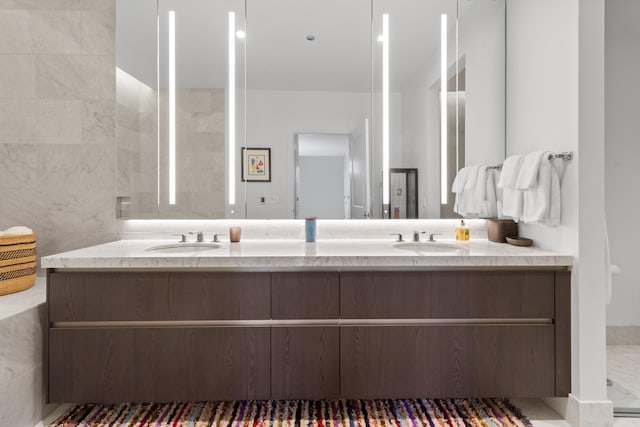 bathroom featuring a sink, tile walls, and double vanity