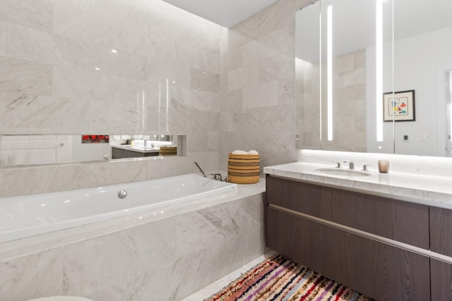 full bath with a garden tub, tile walls, and vanity