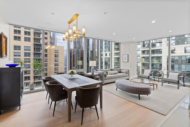 dining space with light wood-style floors, plenty of natural light, and expansive windows