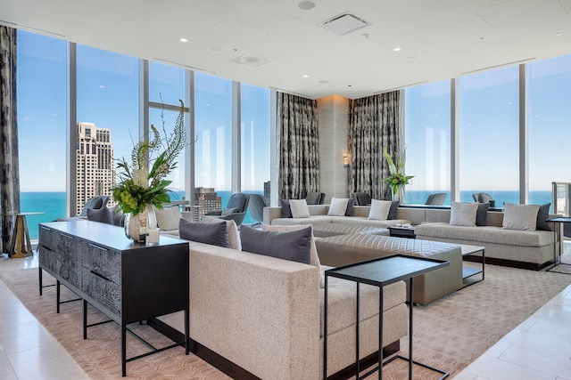 living area featuring expansive windows, a healthy amount of sunlight, and visible vents