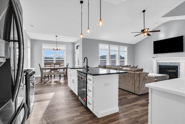 kitchen with a glass covered fireplace, a sink, dark wood-type flooring, appliances with stainless steel finishes, and white cabinetry