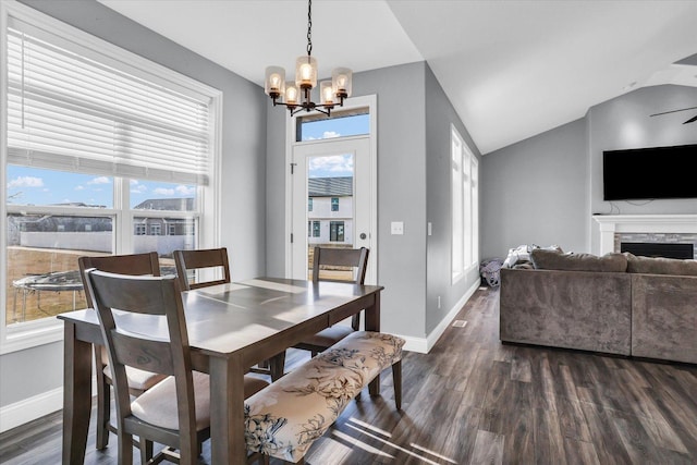 dining area featuring baseboards, dark wood-type flooring, a fireplace, and vaulted ceiling