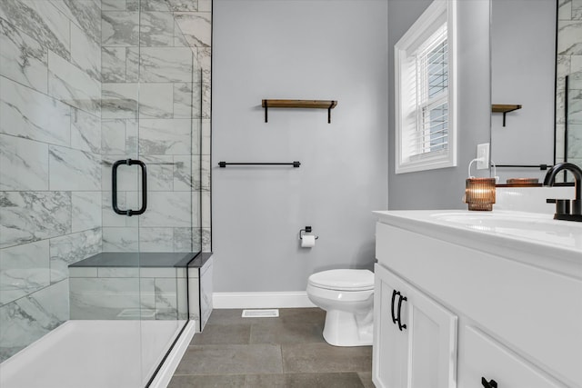 bathroom with toilet, a stall shower, vanity, and baseboards