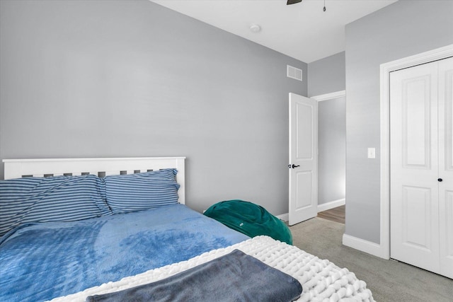 bedroom with visible vents, a closet, carpet flooring, baseboards, and ceiling fan