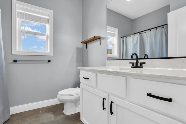 full bathroom with baseboards, toilet, and vanity