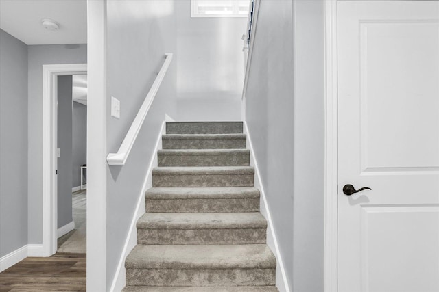 staircase with wood finished floors and baseboards