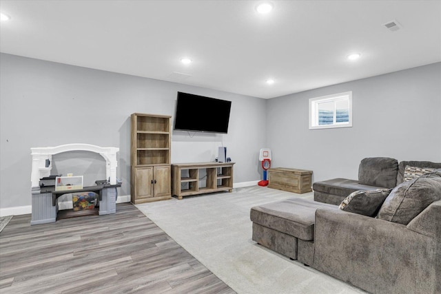 living area featuring recessed lighting, wood finished floors, visible vents, and baseboards