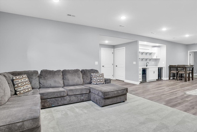 living area featuring visible vents, baseboards, wine cooler, light wood-style flooring, and recessed lighting