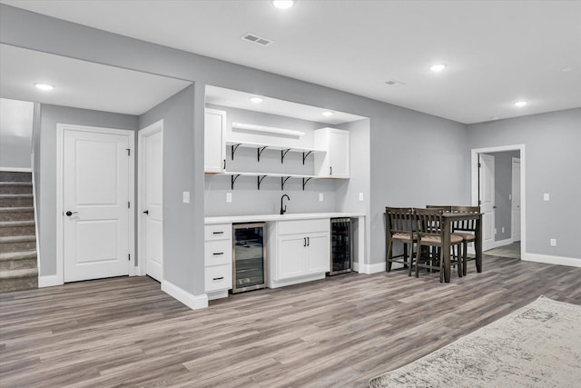 bar featuring wet bar, stairway, beverage cooler, and visible vents