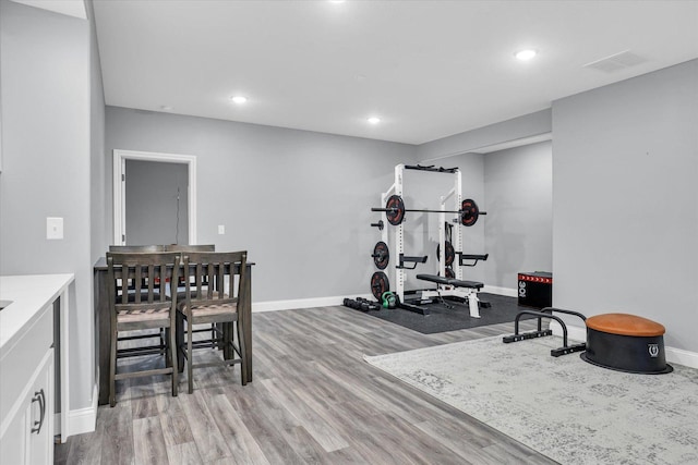 workout area with visible vents, recessed lighting, baseboards, and wood finished floors