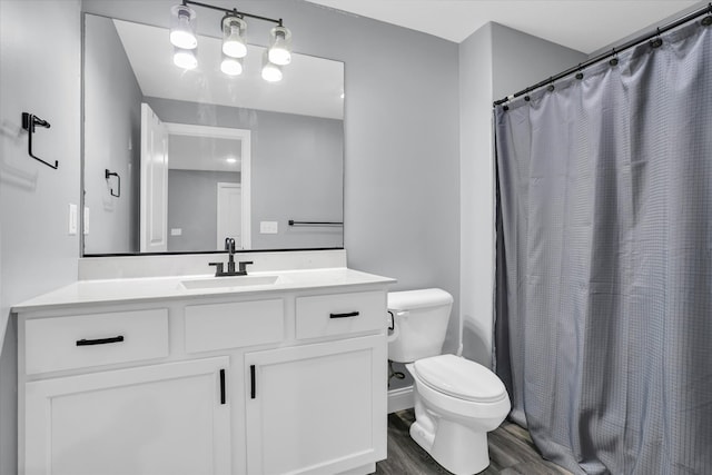 bathroom with a shower with shower curtain, toilet, vanity, and wood finished floors