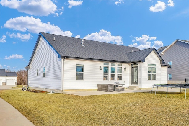 rear view of property featuring a patio, a trampoline, a yard, and roof with shingles