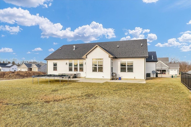 back of property with central AC unit, fence, a yard, a trampoline, and a patio area