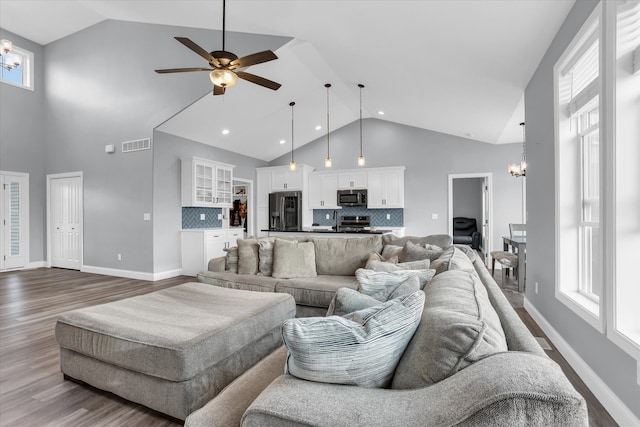 living room featuring visible vents, high vaulted ceiling, dark wood-type flooring, and baseboards