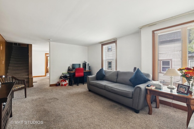 carpeted living room with stairway and baseboards