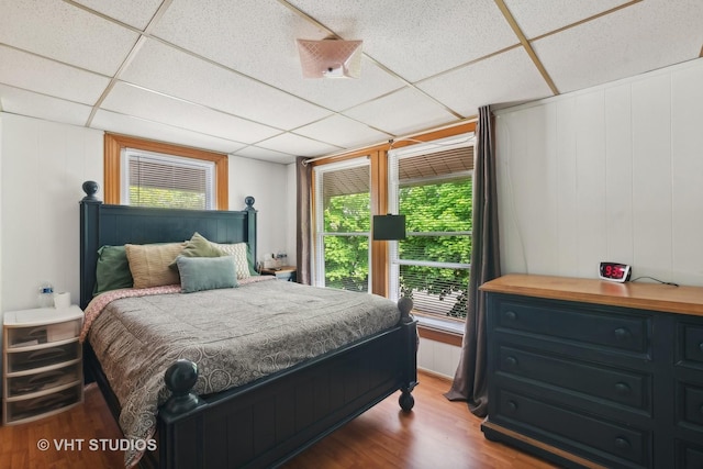 bedroom featuring a paneled ceiling and wood finished floors