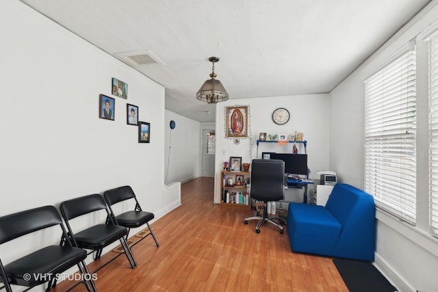 office space with visible vents, light wood-style flooring, and baseboards