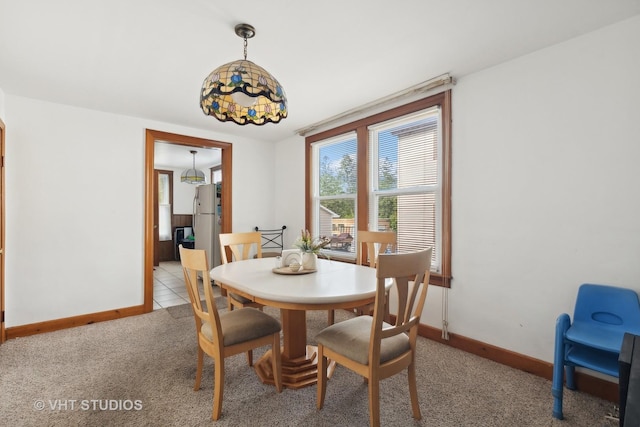 dining room featuring light carpet and baseboards