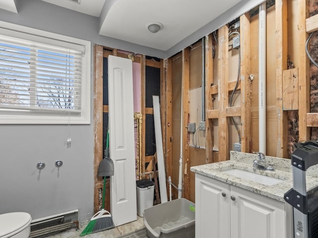 bathroom with toilet, vanity, and baseboard heating