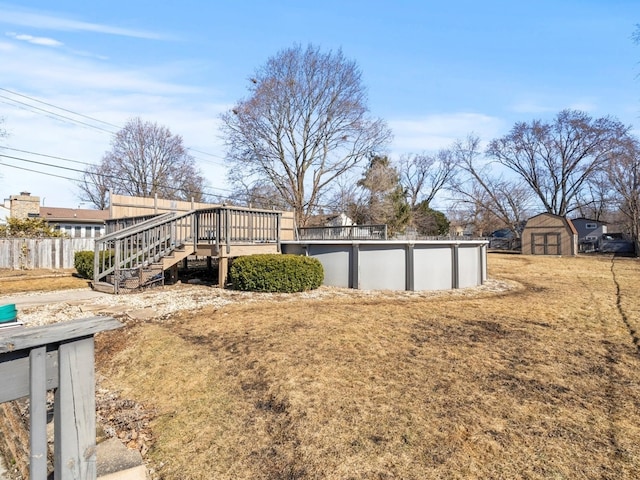 view of yard featuring stairway, an outdoor pool, fence, and a deck