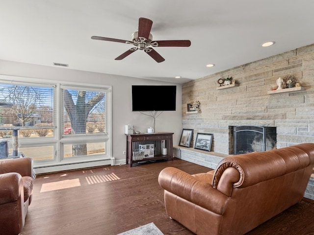 living room featuring a baseboard radiator, recessed lighting, a fireplace, wood finished floors, and visible vents