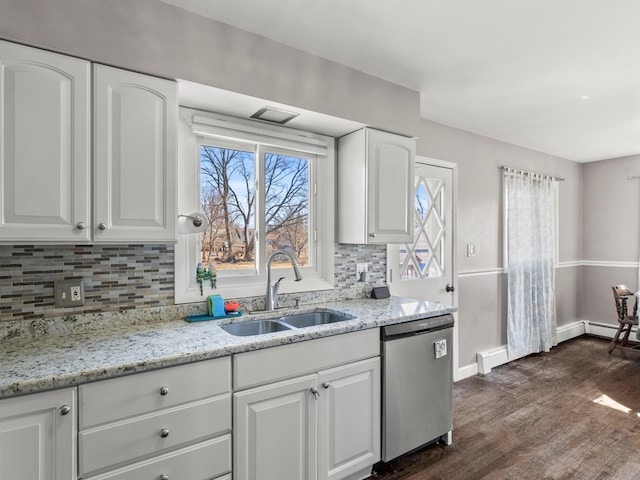 kitchen featuring light stone counters, dark wood-style flooring, stainless steel dishwasher, white cabinetry, and a sink