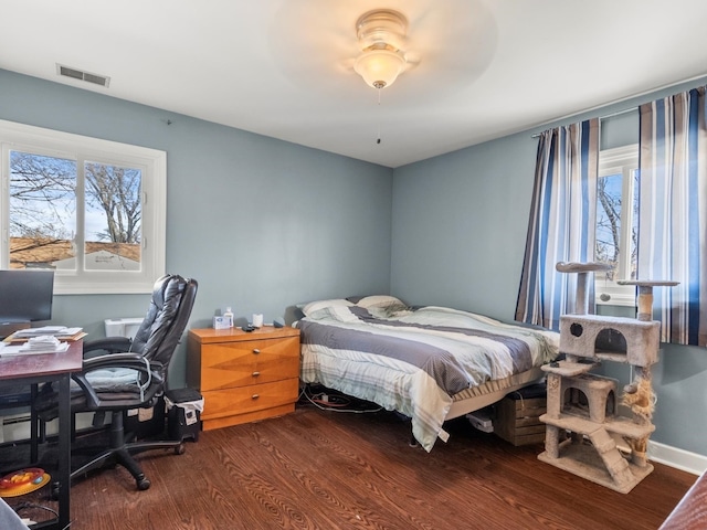 bedroom featuring baseboards, visible vents, and wood finished floors