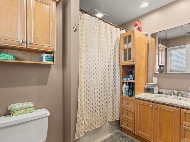 bathroom featuring a shower with shower curtain, vanity, and toilet