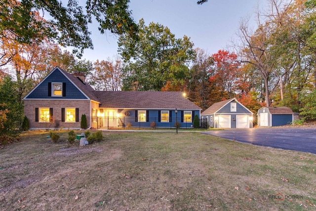 view of front of home with brick siding, an outdoor structure, a detached garage, a shed, and a front yard