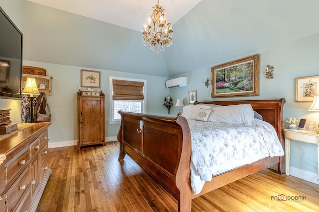 bedroom with baseboards, lofted ceiling, a wall unit AC, light wood-style flooring, and a notable chandelier