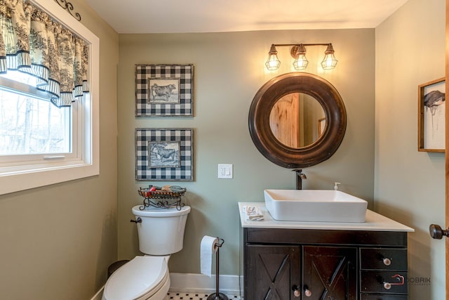 bathroom featuring toilet, baseboards, and vanity