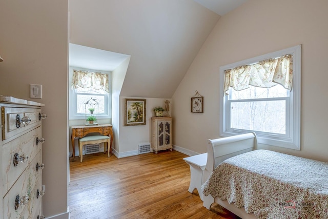 bedroom with light wood-type flooring, visible vents, vaulted ceiling, and baseboards