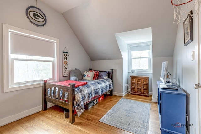 bedroom with light wood-type flooring, baseboards, and vaulted ceiling