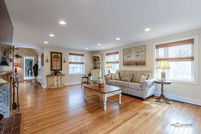 living area with baseboards, light wood-type flooring, and recessed lighting