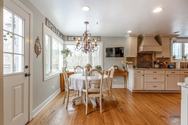 dining room featuring recessed lighting, baseboards, light wood finished floors, and an inviting chandelier