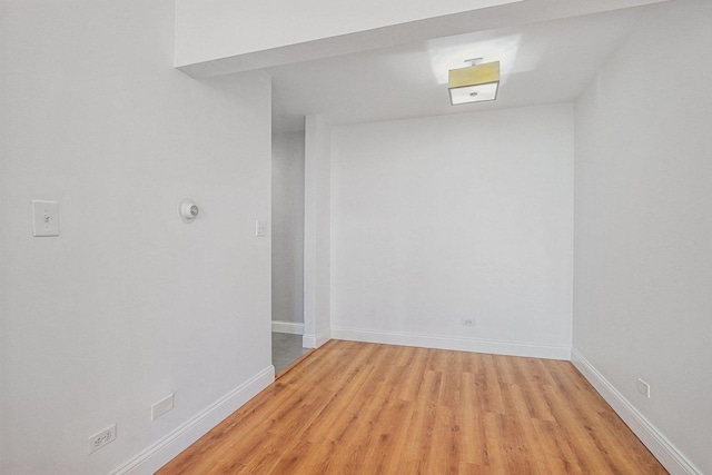 unfurnished room featuring baseboards and light wood finished floors