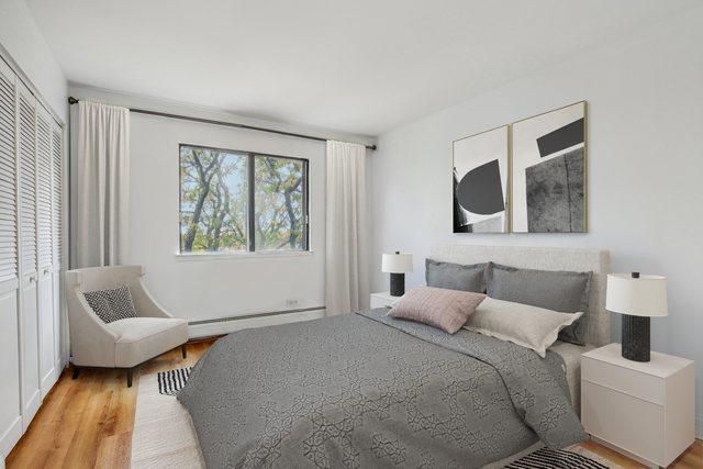 bedroom with baseboard heating and light wood-type flooring