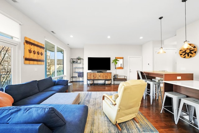 living area with dark wood-style flooring, visible vents, and recessed lighting