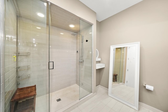 bathroom with a stall shower, tile patterned flooring, baseboards, and recessed lighting