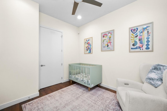 bedroom featuring baseboards, a ceiling fan, wood finished floors, a nursery area, and recessed lighting