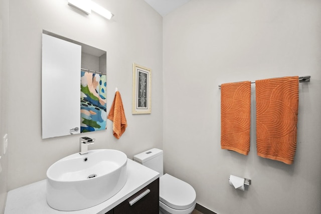 bathroom featuring curtained shower, vanity, and toilet